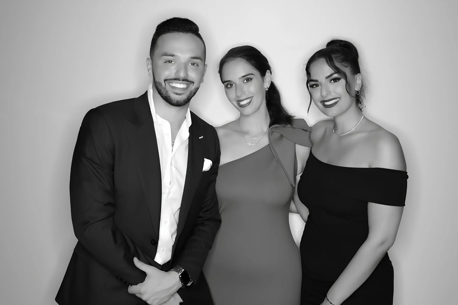 Trio in formalwear posing in a black and white Glam Booth photo